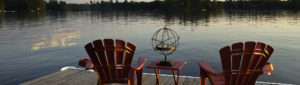 Picture of muskoka chairs near a lake